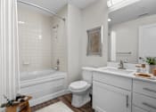 Thumbnail 5 of 30 - A white bathroom with a tub, toilet, and sink.