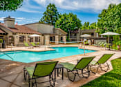 Thumbnail 20 of 33 - Pool surrounded by lounge chairs at Eagle Point Apartments, New Mexico, 87111
