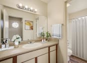 Thumbnail 9 of 13 - A bathroom with a sink, mirror, and toilet.