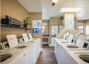 Thumbnail 13 of 13 - A laundromat with rows of washers and dryers.