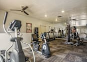 Thumbnail 4 of 13 - A spacious gym with a variety of equipment including treadmills, stationary bikes, and weight machines.