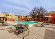 Thumbnail 7 of 13 - A pool area with a table and chairs.