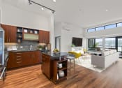 Thumbnail 4 of 51 - Kitchen and living room with a couch and a table at Equinox, 98102