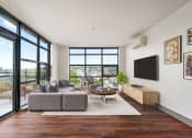 Thumbnail 10 of 51 - Living room with a couch and a coffee table and large windows at Equinox, Seattle, WA, 98102