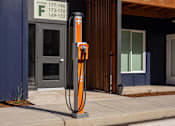 Thumbnail 34 of 34 - A tall orange pole with a cross on it stands in front of a building.