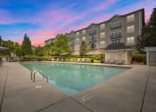 Thumbnail 6 of 21 - a swimming pool with an apartment building in the background