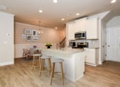 Thumbnail 16 of 60 - a kitchen with white cabinets and a white counter top with three stools in front of it