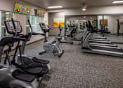 Thumbnail 13 of 33 - A gym with treadmills, elliptical machines, and other exercise equipment.