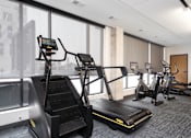 Thumbnail 32 of 34 - A gym with treadmills and elliptical machines.