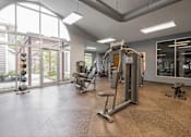 Thumbnail 27 of 39 - A gym with a variety of equipment including a treadmill, weights, and a bench.