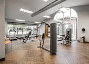 Thumbnail 25 of 39 - A gym with a variety of equipment including treadmills, weights, and exercise machines.