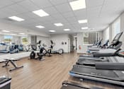 Thumbnail 40 of 50 - A gym with treadmills, exercise bikes, and other equipment.