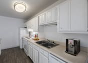 Thumbnail 16 of 25 - A kitchen with white cabinets and a black coffee maker on the counter.