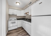 Thumbnail 6 of 23 - an empty kitchen with white appliances and white cabinets