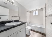 Thumbnail 8 of 23 - a bathroom with a sink and a toilet and a bath tub