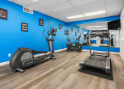 Thumbnail 9 of 23 - a gym with various exercise machines and a blue wall