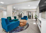 Thumbnail 13 of 23 - a living room with two blue chairs and a coffee table