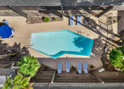 Thumbnail 16 of 23 - Aerial view of outdoor pool with lounge chairs and shaded seating area.