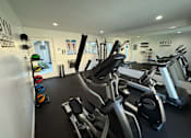 Thumbnail 17 of 17 - A gym with a variety of exercise equipment including treadmills, stationary bikes, and weight machines.