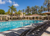 Thumbnail 1 of 28 - a swimming pool with lounge chairs and umbrellas in front of a hotel