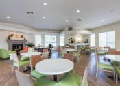 Thumbnail 25 of 28 - a resident clubhouse with tables and chairs and a fireplace