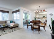 Thumbnail 9 of 28 - a living room and dining room area with white walls and carpeted flooring