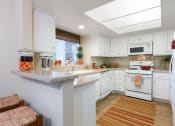 Thumbnail 4 of 28 - a kitchen with white cabinets and a white stove top oven