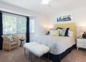 Thumbnail 13 of 28 - a bedroom with a bed and a chair in front of a window