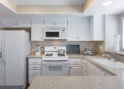 Thumbnail 3 of 28 - a kitchen with white cabinets and a white stove top oven