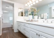 Thumbnail 16 of 28 - a bathroom with white cabinets and a large mirror
