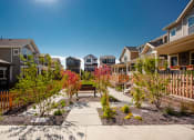 Thumbnail 29 of 51 - a group of houses with a walkway and benches in a garden