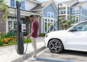 Thumbnail 14 of 29 - a man is charging his car at a gas pump