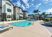 Thumbnail 3 of 31 - A swimming pool surrounded by apartment buildings.