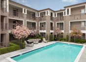 Thumbnail 12 of 17 - an apartment building with a swimming pool in front of it