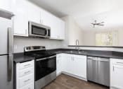 Thumbnail 3 of 17 - a kitchen with white cabinets and stainless steel appliances
