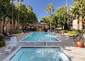 Thumbnail 5 of 24 - A pool surrounded by trees and chairs.
