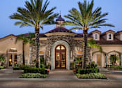 Thumbnail 25 of 33 - A large house with a brown roof and a stone archway entrance.