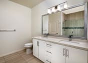 Thumbnail 7 of 33 - A bathroom with a toilet, sink, and mirror.
