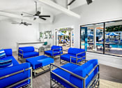 Thumbnail 12 of 22 - A room with blue chairs and a ceiling fan.