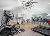 Thumbnail 2 of 22 - A spacious gym with treadmills, elliptical machines, and other exercise equipment.