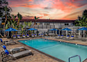 Thumbnail 16 of 22 - A pool surrounded by lounge chairs and umbrellas.
