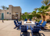 Thumbnail 7 of 47 - an outdoor patio with blue chairs and a fire pit