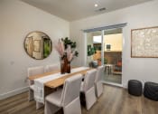 Thumbnail 20 of 47 - a dining room with a table and chairs and a mirror on the wall