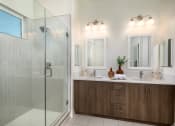 Thumbnail 31 of 47 - a bathroom with a shower and two sinks