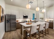 Thumbnail 1 of 47 - a kitchen with a large island and a stainless steel refrigerator