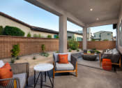 Thumbnail 29 of 47 - a covered patio with chairs and tables and a fire pit