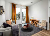 Thumbnail 15 of 48 - a living room with white walls and a sliding glass door that leads to a balcony at VORA LUX, California