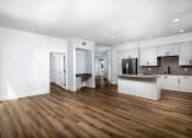 Thumbnail 19 of 48 - an open living room and kitchen with white walls and wood floors at VORA LUX, California, 92120