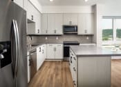 Thumbnail 22 of 48 - a kitchen with white cabinets and stainless steel appliances at VORA LUX, San Diego, CA
