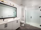 Thumbnail 11 of 48 - a bathroom with a toilet sink mirror and shower at VORA LUX, San Diego, CA 92120